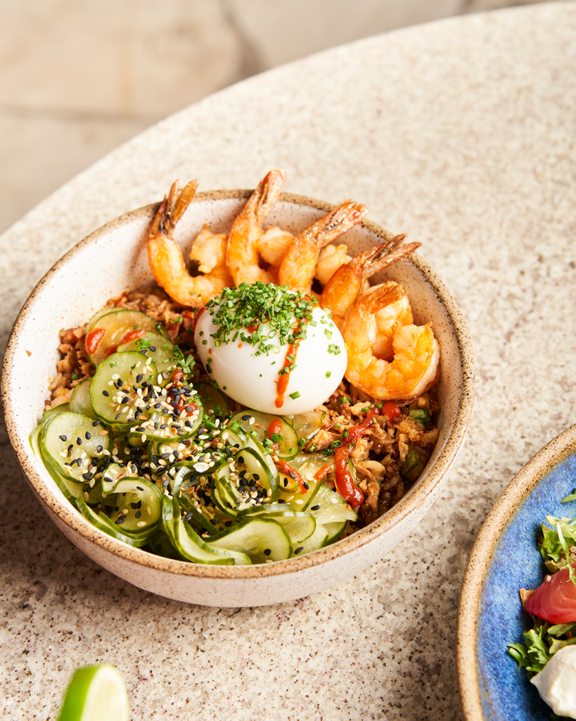 Nasi Goreng: arroz jasmim, servido com legumes e amendoim puxados na wok com molho oriental, alho e cebola fritos, camarões, ovo mollet, sunomono, gergelim, pimenta sriracha, molho teriyaki e cebolete • Lais Acsa