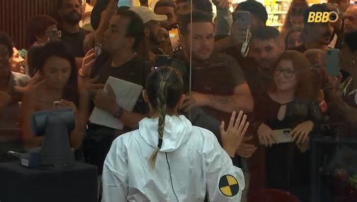 A participante está ouvindo fofocas e conselhos do público do reality show