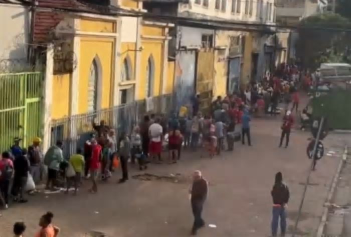 Multidão se reúne em fila para entrega gratuita de peixe no Bonfim, em BH