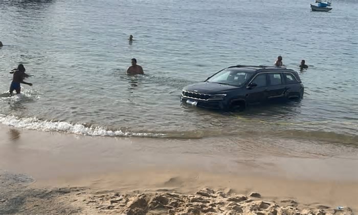 VÍDEO: motorista estaciona carro na praia do Porto da Barra e veículo é parcialmente submerso após maré subir