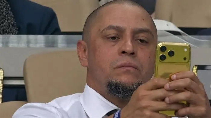 A imagem de um “iPhone de ouro” utilizado pelo ex-jogador Roberto Carlos, exibida pela transmissão oficial da Copa do Mundo ...